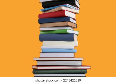 Stack of hardcover books on orange background