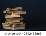 Stack of hardcover old books with an open book on a dark background. Bookshelf shop, Knowledge publications, literature. Bookish bookstore bookstore.