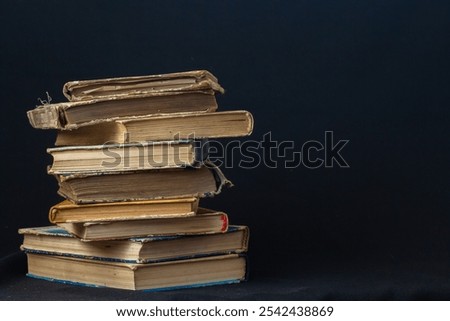 Stack of hardcover old books with an open book on a dark background. Bookshelf shop, Knowledge publications, literature. Bookish bookstore bookstore.