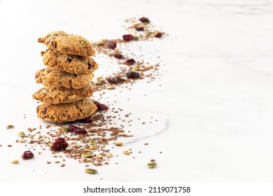 A Stack Of Healthy Trail Mix Cookies With A Trail Of The Mix In Behind.