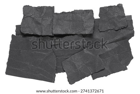 Stack or heap of black crumpled scraps, stripes or snippets of paper or cardboard, isolated on white background