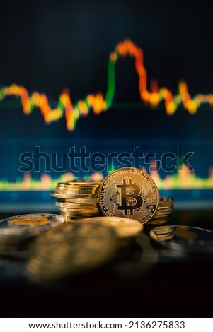 Stack or heap of gold Bitcoins cryptocurrency with candle stick graph chart and digital background.