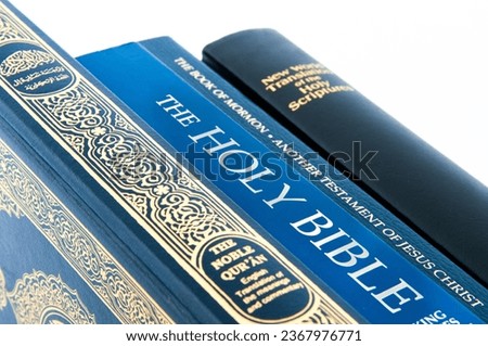 Stack of holy books - New World Translation of the Holy Scriptures, Book of Mormon, Holy Bible and the Qu'ran ( 