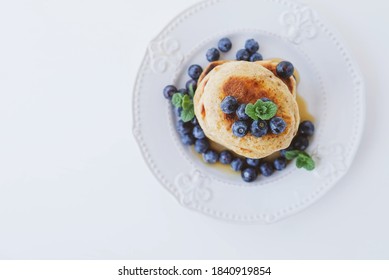 Stack Of Homemade Small Thick Pancakes Made With Whole Wheat Flour Served With Fresh Blueberry And Mint Leaves. Space For Text. Traditional Eastern European Dish. Sweet Healthy Food.