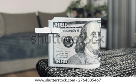 Stack of hundred dollar bills fastened with wooden clothespin on grey surface, money saving and financial management concept