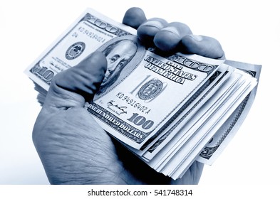 A stack of hundred dollar bills in his hand.