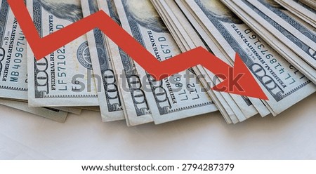 Stack of hundred-dollar bills with red downward arrow. Arrow implies decline or loss in financial value. Visual metaphor for economic downturn or market drop. Commonly used for business, finance