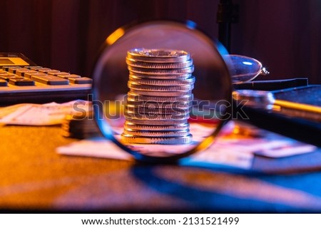 A stack of iron money. View of a small change through a magnifying glass. Pocket money under a magnifying glass. Front view.