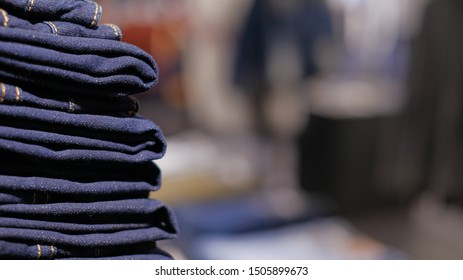 stack of jeans or denim with blurred background and copy space. concept for typography and advertisement of fashion, shopping and business.