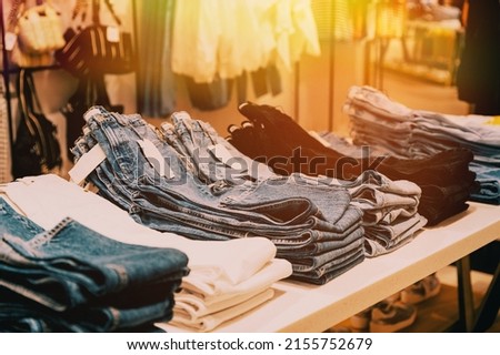 Stack Of Jeans On Shelves In Store Of Shopping Center. shelf display in shop mall store. Store Of Shopping Center. retail sale.