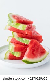 A stack of juicy watermelon slices against a white background.
