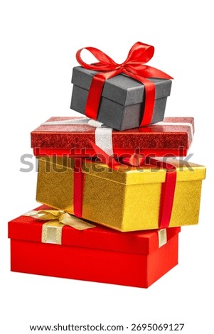 Stack of luxury gift boxes in gold, red, and black colors with satin ribbons and bows, isolated on white. Christmas or New Year composition symbolizing holiday celebration, surprise, and giving.