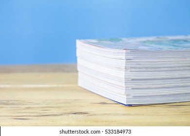 Stack  Of Magazine On Wooden Table Over Blue Background