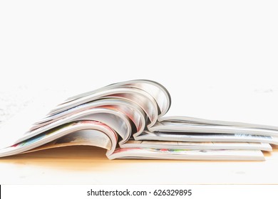 Stack Of Magazine Open On Table With White Background. Copy Space.