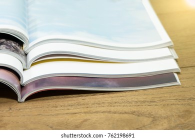 Stack magazines on wooden table.