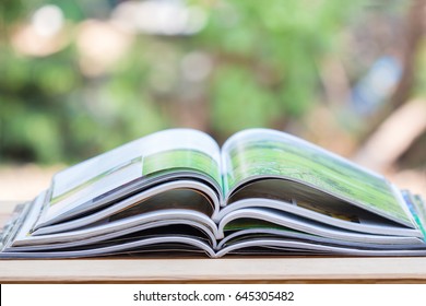 Stack Of Magazines Open Page On Table