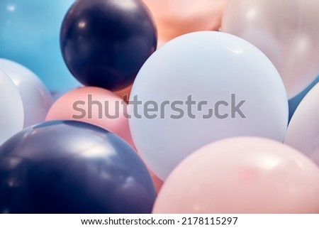Stack of many balloons of different colors and sizes placed in light decorated room during holiday celebration