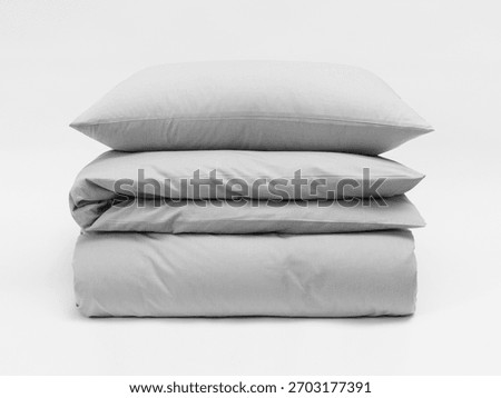 Stack of matte gray bed linen on a white background, a pillow separate from a blanket, bedding items on a white background, a mock-up of bed linen. Front view photo