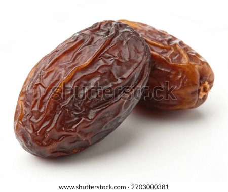 Stack of Medjool Dates behind on white background