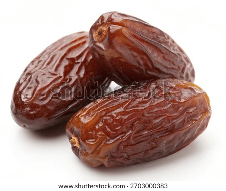 Stack of Medjool Dates behind on white background