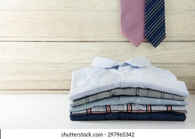 Stack of men shirts and tie hanging with white wooden background - Powered by Shutterstock