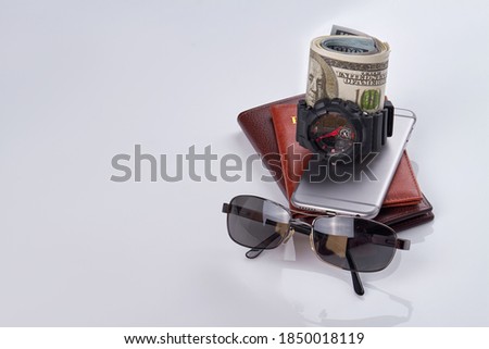 Stack of mens stuff isolated on white. Handwatch with money and sunglasses.