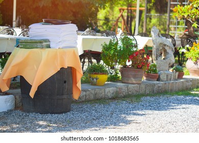 A stack of menus in the area, staff café. The interior of the restaurant is outdoors. A stack of white tablecloths is on a wooden barrel of whiskey. - Powered by Shutterstock