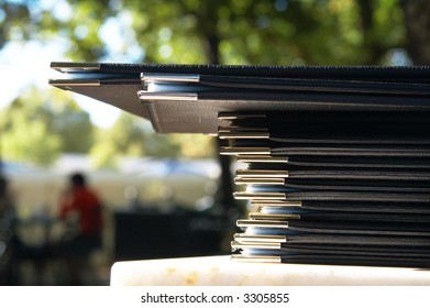 Stack Of Menus Lying On Marble Table At A Coffee Shop On A Summer Day.