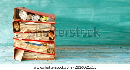 stack of messy files and ringbinders, red tape, bureaucracy,messy office, overworked staff business concept. Large free copy space, negative space technique