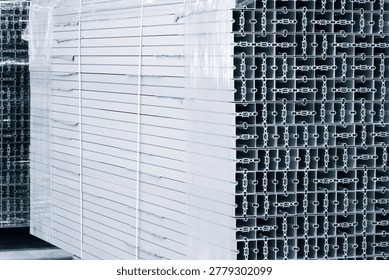 Stack of metal structural parts with square cross-section and many small holes. Industrial constructions for building background