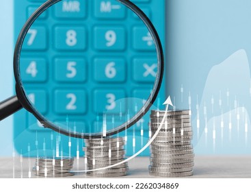 A stack of metallic coins and a chart with growing rates. High income in business, price increase, profit analysis - Shutterstock ID 2262034869