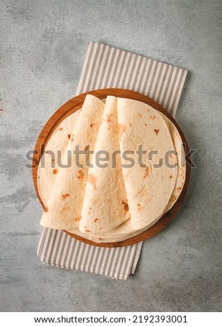 A stack of Mexican tortillas, on a gray table, top view, close-up, no people,