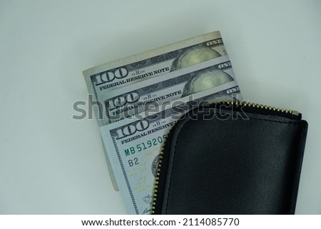Stack Money inside black wallet. US Dollars (USD) banknotes on white background. Concept for business, finance, economy, investment and currency.