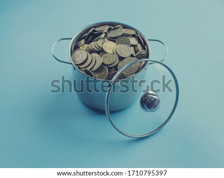 
A stack of money on a blue background with a pot behind them.