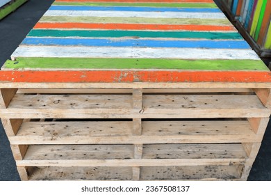 Stack of multicolor wooden pallets following the Australian standard 1165 x 1165 mm size as for to fit exactly in the RACE container of the Australian railways. Queen Victoria Market-Melbourne.