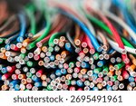 A stack of multicolored copper electrical wires, close-up cross-section view