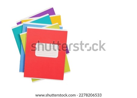 A stack of multicolored school notebooks lies chaotically, highlighted on a white background.Purchase, sale of school supplies, stationery store.Copyspace