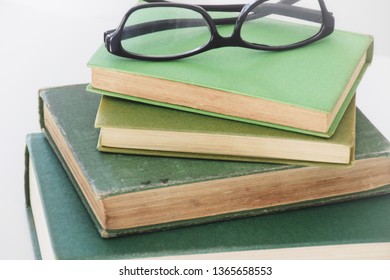 Stack Of Multiple Green Jacket Books With Reading Glasses