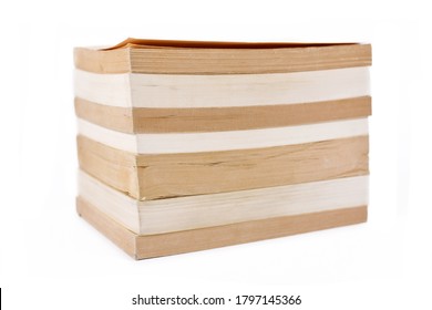Stack of multiple old and yellowed stacked paperback books isolated on white background