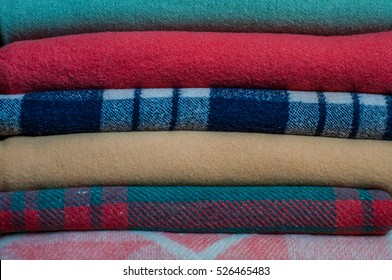 A Stack Of Neatly Folded Colored Blankets