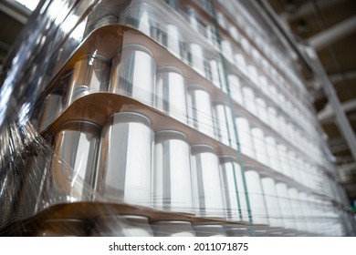 Stack Of New Aluminum Cans Stacked On Pallet Rack In Brewery Warehouse. Cold Drinks And Beer Manufacturing Background