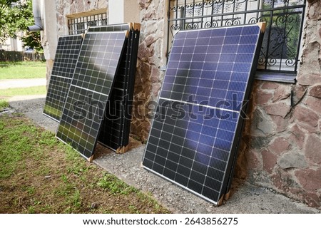 Stack of new solar panels with protective cardboard, ready for installation. Renewable energy, sustainable home improvements, and eco-friendly investments in residential property infrastructure.