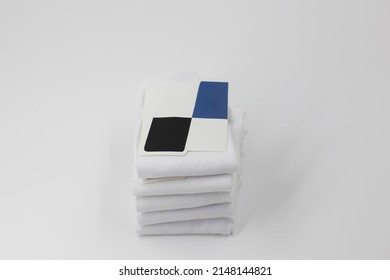 Stack Of New White Socks With Blank Labels On White Background, Close-up Top View