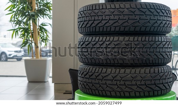 Stack of new winter tires. Group of automotive\
tires for snow road. Selective focus. Sale tires in shop. Safety\
concept.