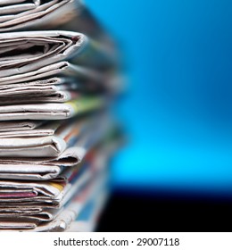 Stack Of Newspaper On Blue Background