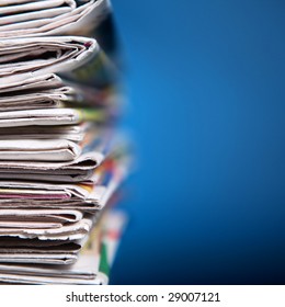 Stack Of Newspaper On Blue Background