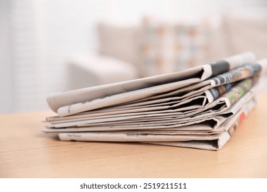 Stack of newspapers in different languages on table indoors, closeup