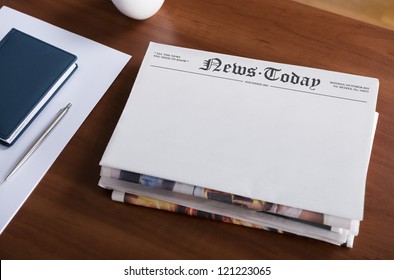 A stack of newspapers with headline "News Today" and blank space for information lying on the office desktop.