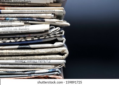 Stack of newspapers on black background - Shutterstock ID 159891725