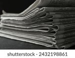 Stack of newspapers on dark stone table, closeup. Journalist